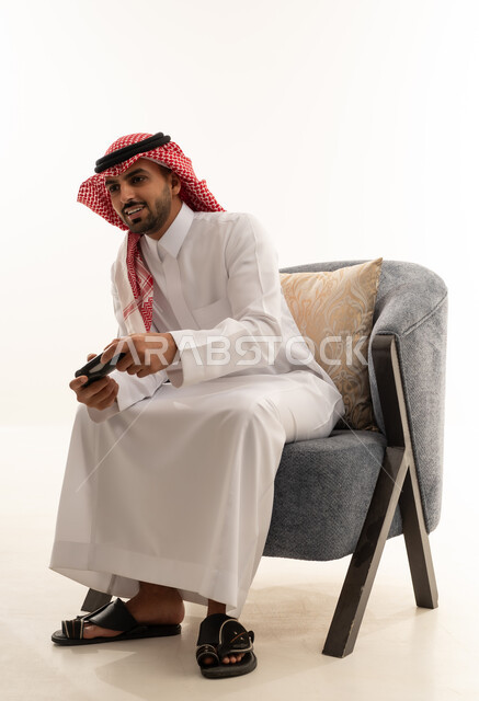رجل سعودي يلعب ألعاب الفيديو بالثوب التقليدي