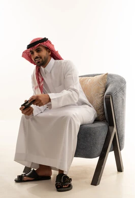 رجل سعودي يلعب ألعاب الفيديو بالثوب التقليدي