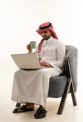 رجل سعودي يستخدم اللابتوب بالثوب والشماغ التقليدي