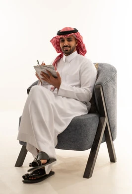 Saudi Man in Traditional Thobe Writing on Clipboard