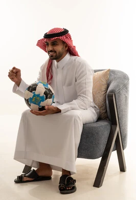 رجل سعودي بالزي التقليدي يحتفل بكرة القدم