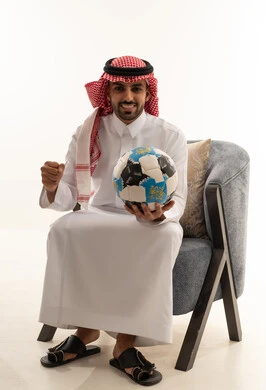 Saudi Man Holding Soccer Ball in Traditional Thobe