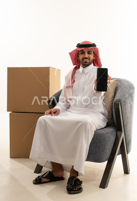 رجل سعودي مع هاتف ذكي وصناديق شحن