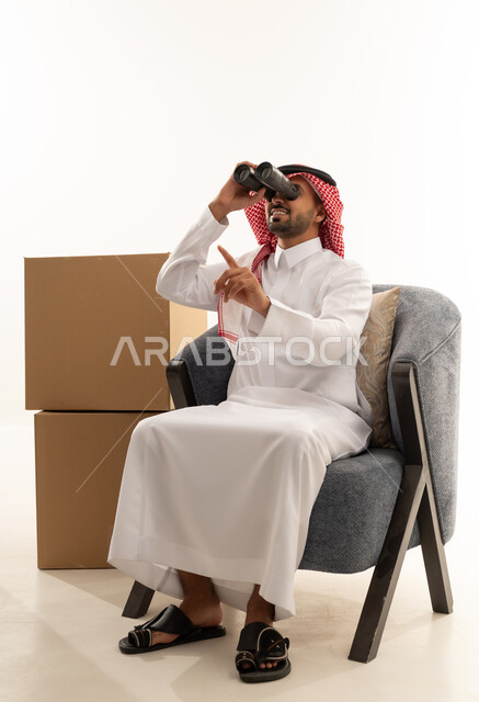 Saudi Man in Thobe Using Binoculars with Boxes