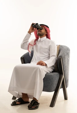 Saudi Man in Traditional Thobe Using Binoculars