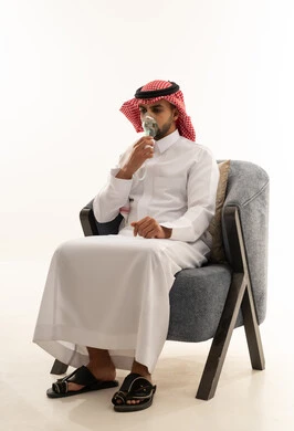 رجل سعودي بالثوب يستخدم جهاز البخار للتنفس