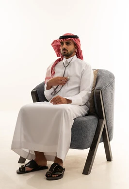 رجل سعودي بالثوب التقليدي يستخدم سماعة طبية