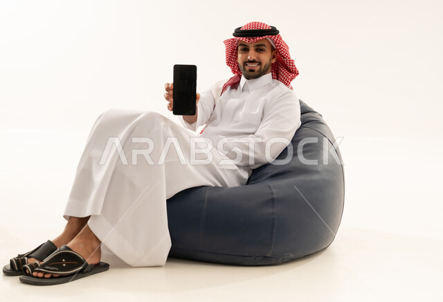 Saudi Man in Traditional Thobe Holding Smartphone