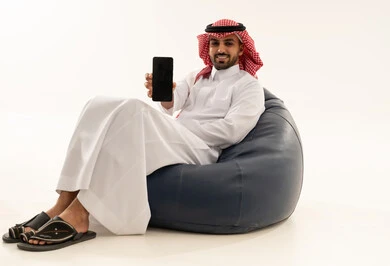 Saudi Man in Traditional Thobe Holding Smartphone