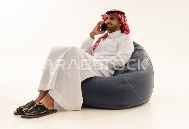 Saudi Man Talking on Smartphone on Beanbag Chair