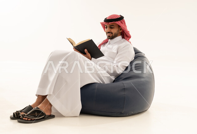 Saudi Man in Thobe Reading on Bean Bag