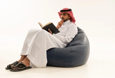 Saudi Man Reading Book on Bean Bag in Studio