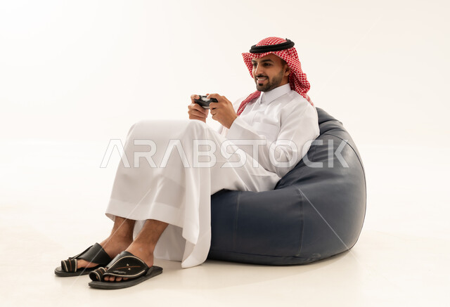 رجل سعودي يلعب ألعاب الفيديو على كرسي مريح