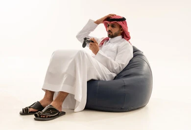 رجل سعودي يلعب ألعاب الفيديو بتركيز