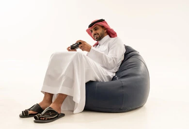 شاب سعودي يلعب ألعاب الفيديو على كرسي بين باج