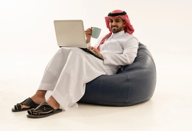 رجل سعودي يستخدم اللابتوب على مقعد محشو