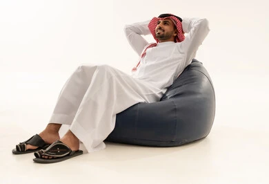 Saudi Man in Traditional Thobe Relaxing on Bean Bag