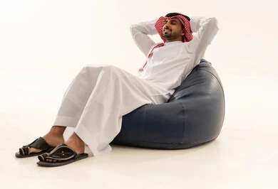 Saudi Man in Traditional Thobe Relaxing on Beanbag
