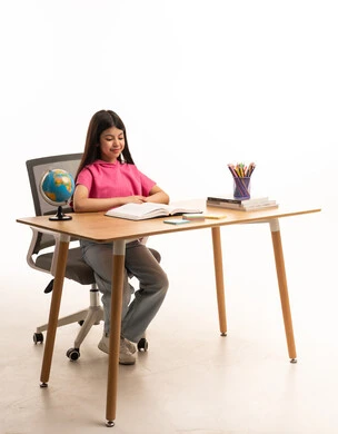 Saudi Girl Reading at Desk with Education Supplies