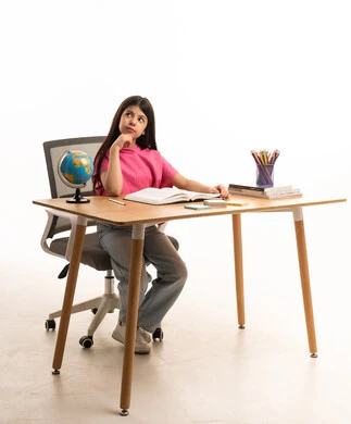 طالبة عربية بوضعية التفكير على المكتب الدراسي