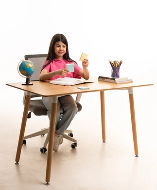 طالبة عربية تدرس على مكتب خشبي أمام خلفية بيضاء