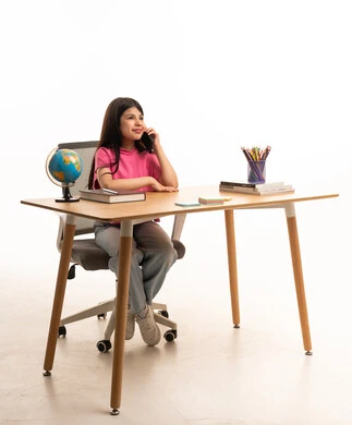 Saudi Girl Talking on Phone at Study Desk