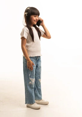 طفلة سعودية تتحدث عبر الهاتف الذكي في استوديو