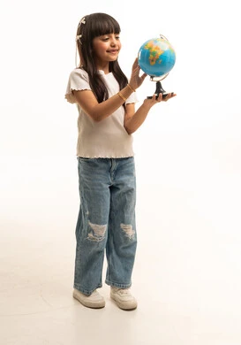 طفلة سعودية تمسك كرة أرضية بخلفية بيضاء