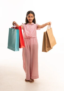 فتاة عربية سعودية تمسك أكياس تسوق بخلفية بيضاء