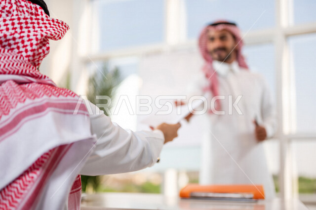 مناقشة عمل بين رجل أعمال ومدير الشركة , اجتماع رجال أعمال في مقر العمل , توزيع مهام العمل , الوحده والعمل الجماعي, تطوير العمل وحل المشكلات لتطوير أهداف الشركة , اتفاقية عمل , بيئة عمل سعودي .