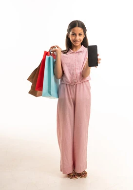 فتاة سعودية تحمل حقائب تسوق وهاتف ذكي