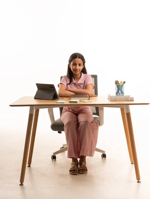 Saudi Girl in Pink Outfit Studying at Wooden Desk