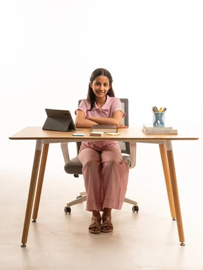 Saudi Girl Sitting at Desk with Tablet and Books