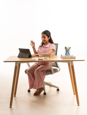 فتاة عربية تستخدم جهاز لوحي على مكتب الدراسة