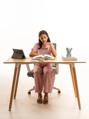 فتاة سعودية بملابس النوم تدرس على المكتب