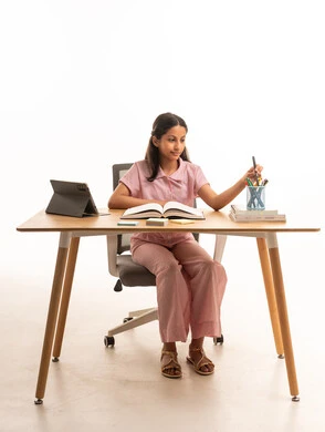 طفلة سعودية تدرس على مكتب بملابس نوم وردية