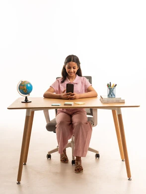 Young Saudi Girl Using Smartphone at Desk Studio Shot