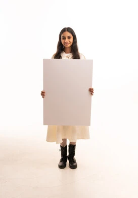 فتاة سعودية تحمل لوحة بيضاء فارغة في الاستوديو