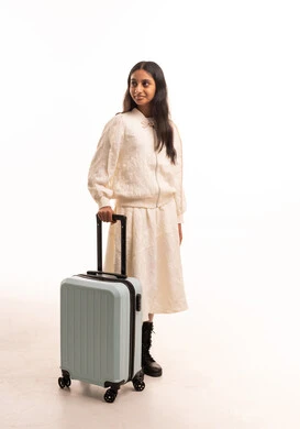 امرأة هندية مع حقيبة سفر في استوديو أبيض