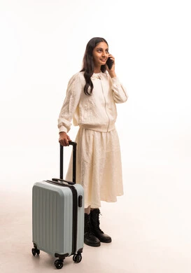 فتاة هندية مع حقيبة سفر تتحدث بالهاتف