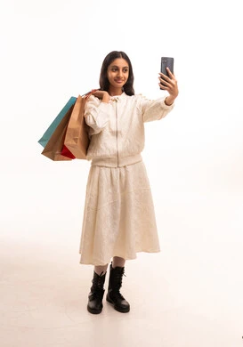 فتاة سعودية تلتقط سيلفي مع حقائب التسوق