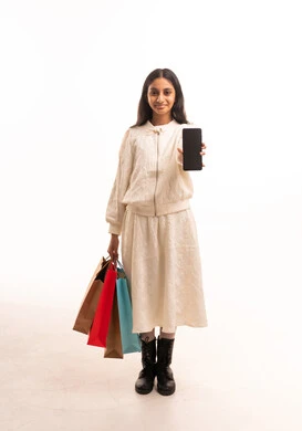 امرأة هندية تحمل هاتف ذكي وحقائب تسوق