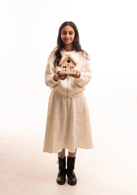 Saudi Girl Holding Wooden Birdhouse Model in Studio