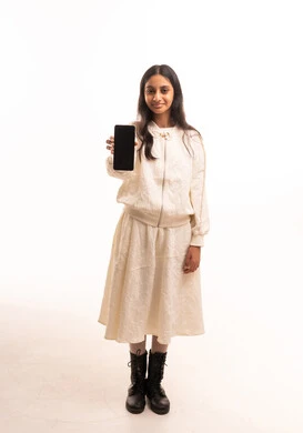 فتاة هندية تحمل هاتفاً ذكياً على خلفية بيضاء