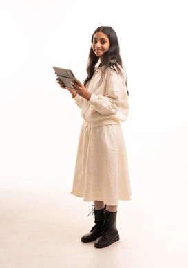 Young Arab Girl in Modest White Outfit Holding Tablet