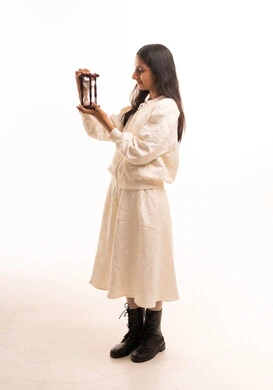 فتاة سعودية تحمل ساعة رملية بخلفية بيضاء