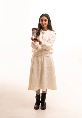 Young Woman Holding Hourglass in White Studio Background