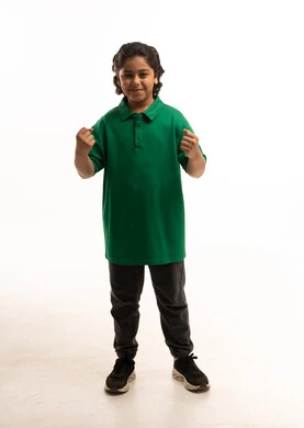 طفل سعودي بقميص بولو أخضر على خلفية بيضاء