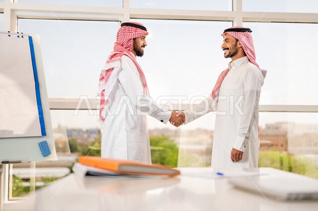 صوره لرجلان عربيان سعوديان خليجيان يتصافحان بحرارة , اتفاقية عمل , صفقة عمل , خطة عمل جديده , نجاح صفقة عمل جديده , شركاء عمل , رجال أعمال , بيئة عمل سعودي .