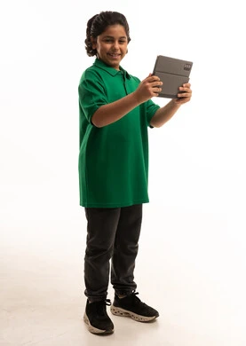 طفل سعودي ممسك بجهاز لوحي على خلفية بيضاء